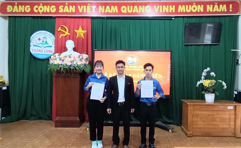 Đồng chí Nguyễn Bá Tân - Bí thư Chi bộ Trường THPT Thăng Long trao Quyết định kết nạp đảng viên cho học sinh Trần Khánh Hoa và học sinh Hồ Phan Minh Tuấn lớp 12A1 (năm học 2022 - 2023)